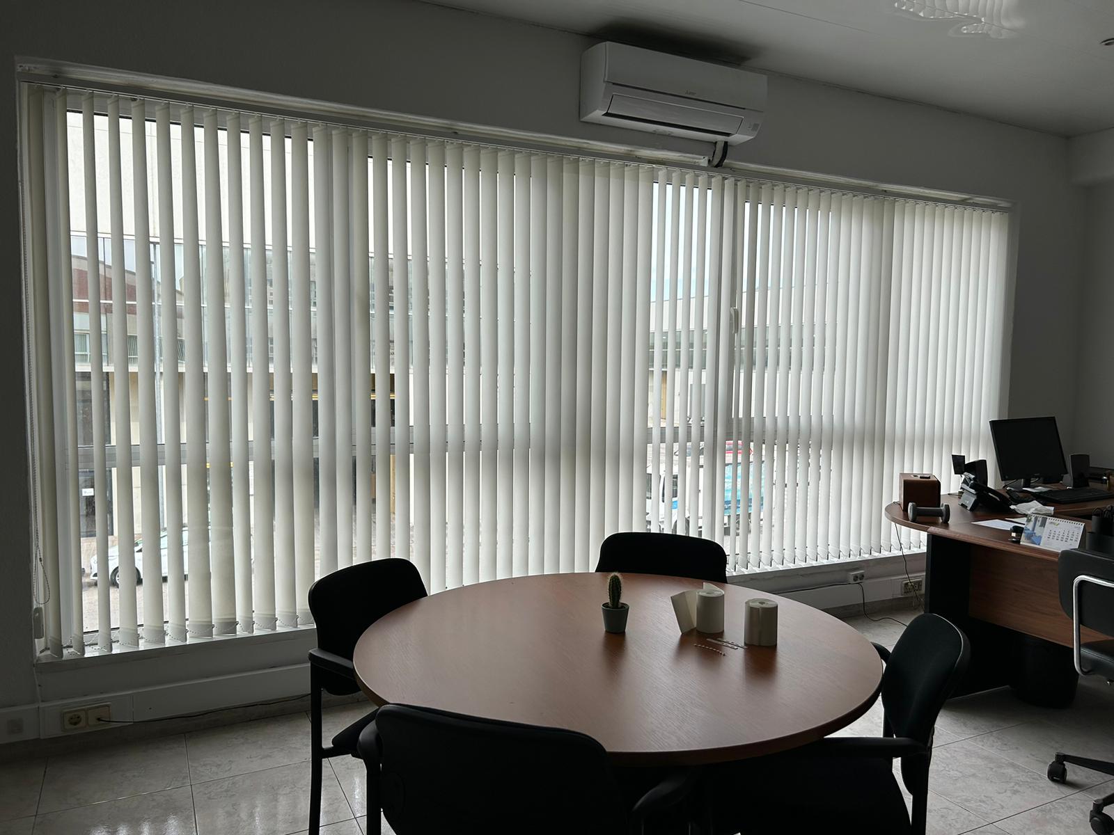 Cortinas verticales con lamas de 89mm instaladas en despacho en Barcelona