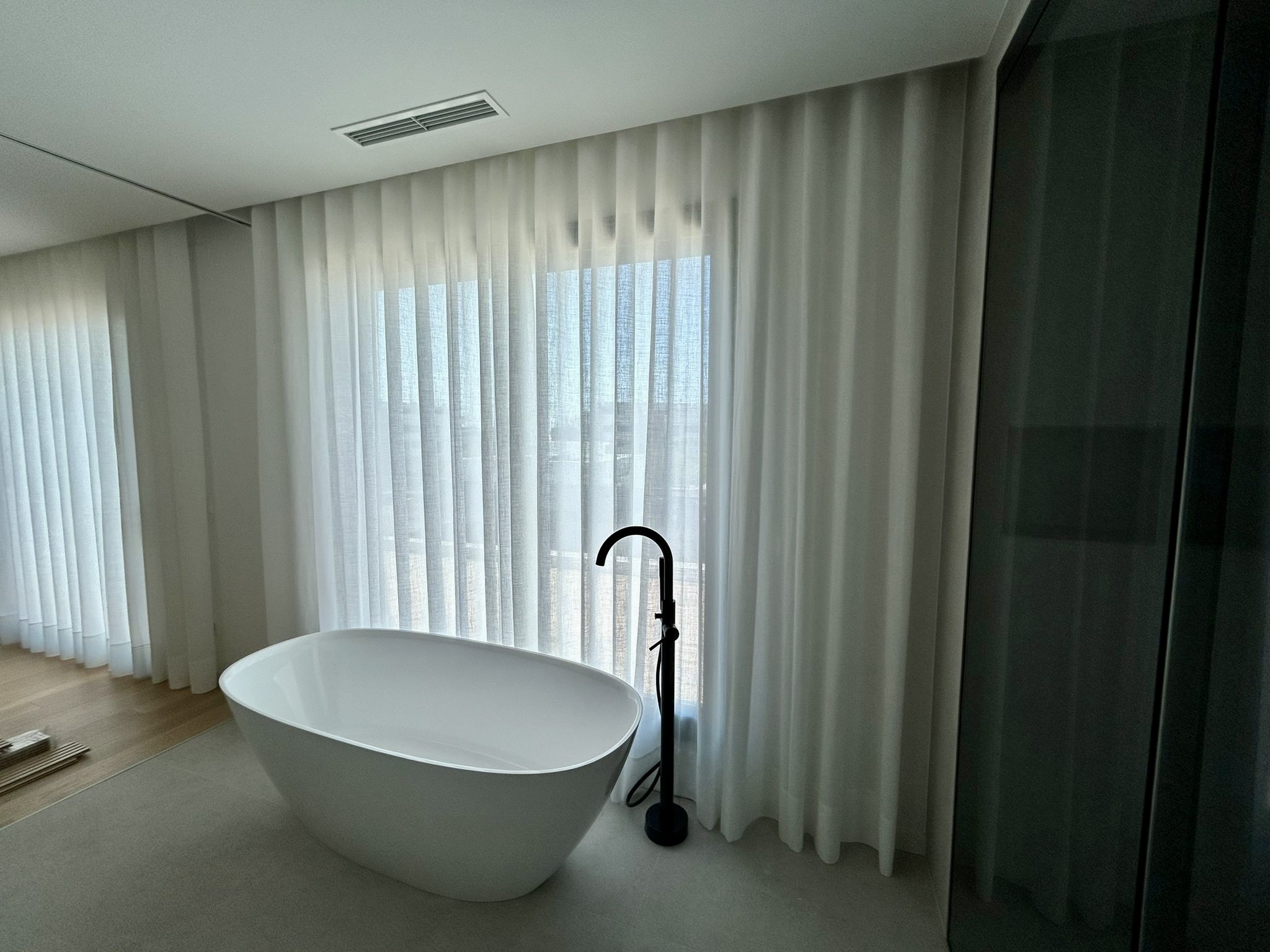 Cortina tradicional con tejido blanco instalada en habitación de vivienda en Sitges