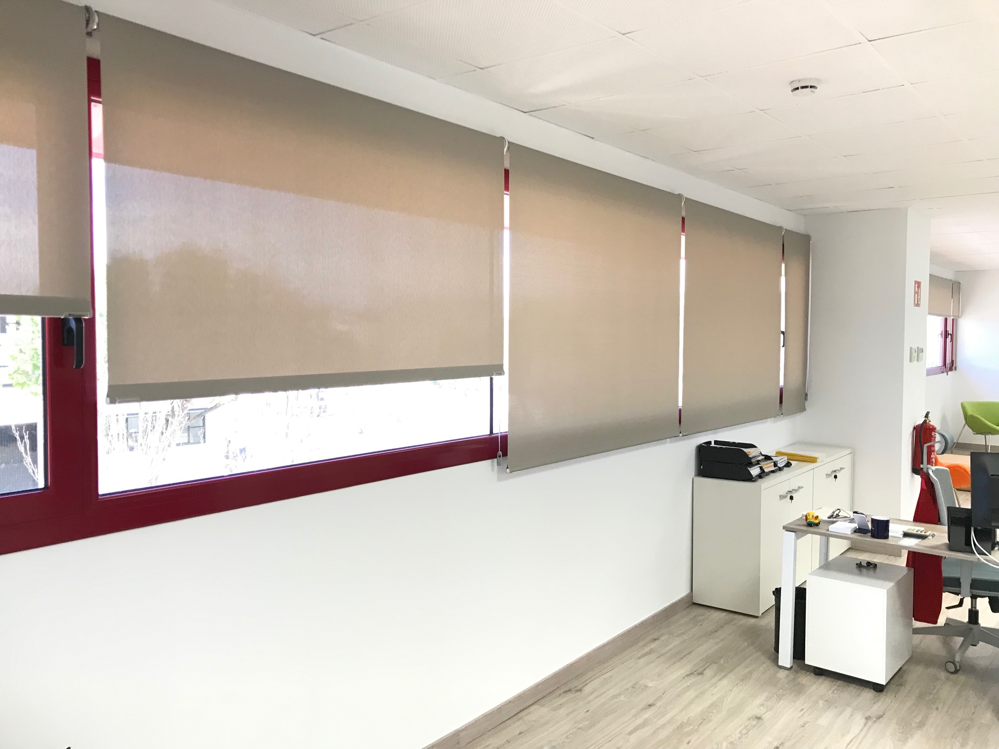 Estores enrollables con tejido técnico screen de color claro en oficina de l'Hospitalet del Llobregat