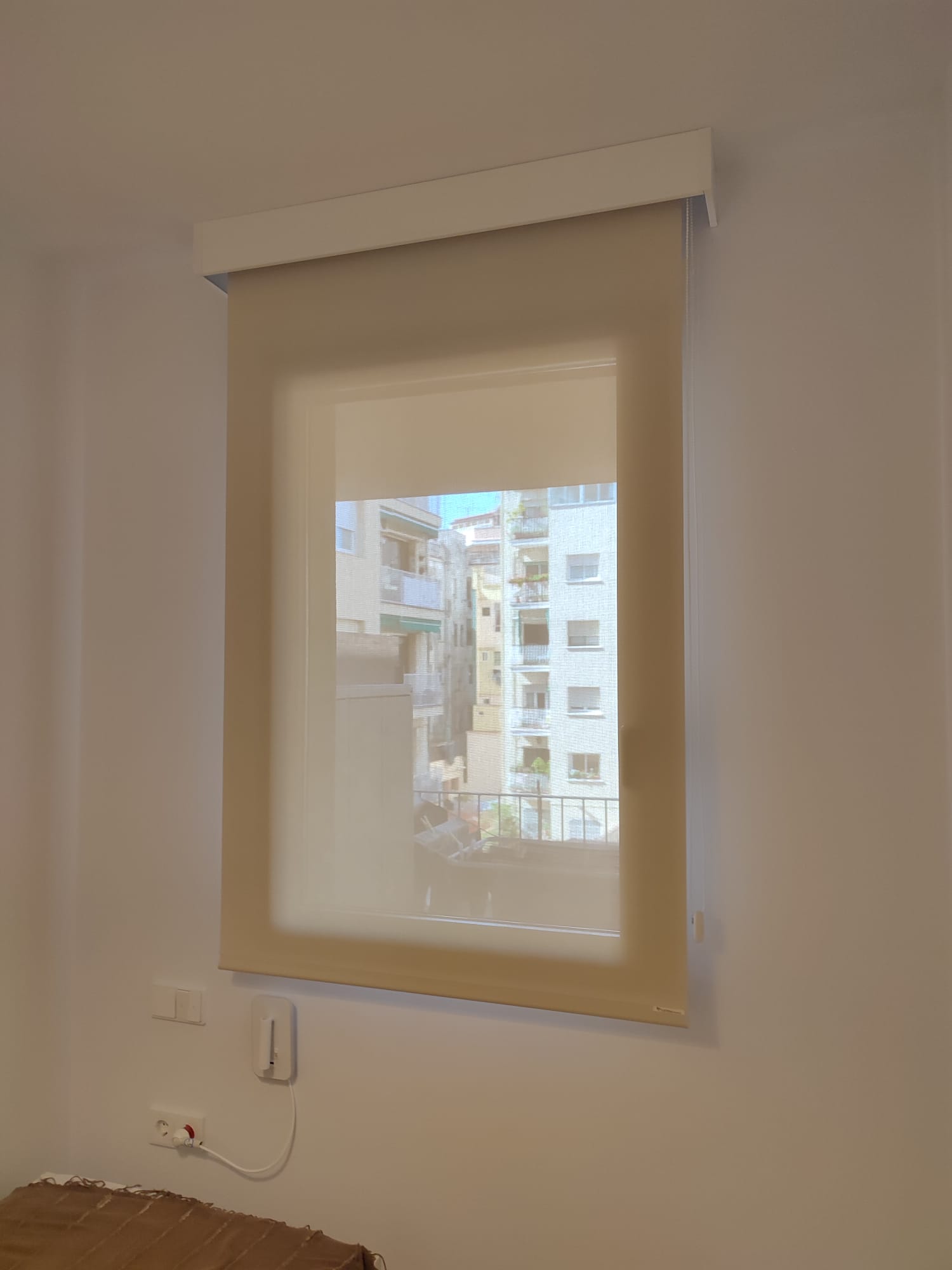 Cortina enrollable en vivienda con frontal decorativo de color blanco