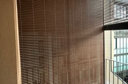 Persiana alicantina de pvc de color marrón, con freno y polea, instalada en balcón para piso turístico en Barcelona