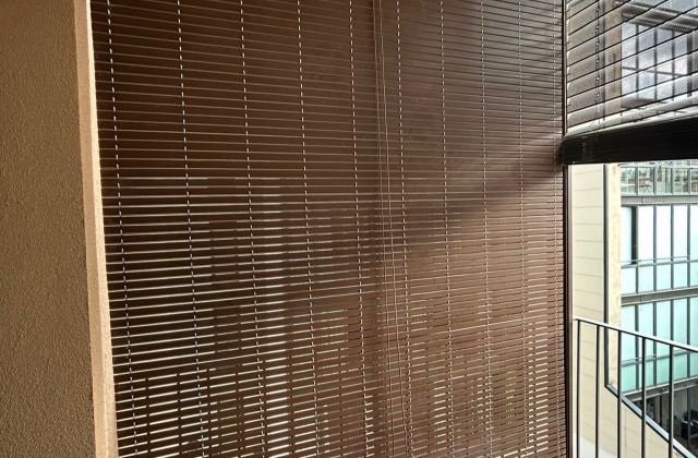 Persiana alicantina de pvc de color marrón, con freno y polea, instalada en balcón para piso turístico en Barcelona