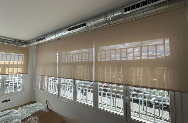 Instalación de cortinas enrollables con tejido técnico screen, referencia 380P abertura del 5% y color White/Linen, en oficinas de Barcelona 