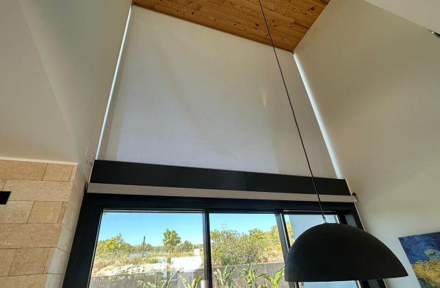 Instalación de cortina enrollable motorizada con tejido técnico screen, referencia 380P abertura del 5% y color White/Linen, en vivienda de Sitges