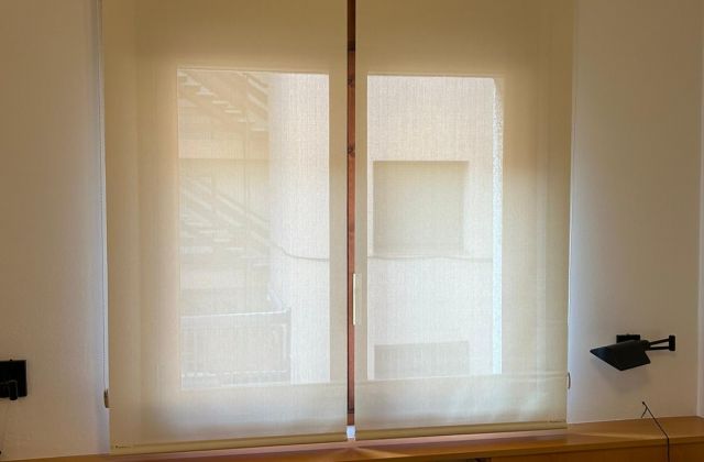 Instalación de cortinas enrollables con tejido técnico screen, referencia 380P abertura del 5% y color White Linen, en vivienda de Cunit
