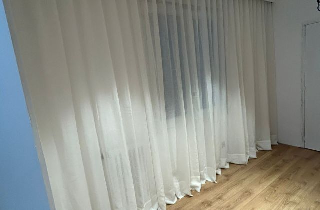 Instalación de cortina tradicional con riel básico, referencia color 10 Nácar, en estudio de Barcelona