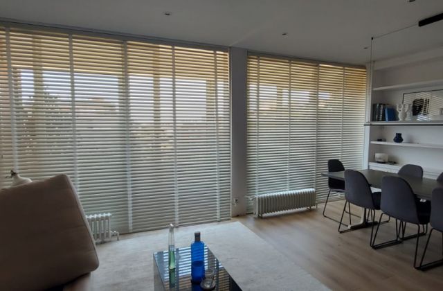 Instalación de cortinas venecianas de aluminio con lamas de 50mm, cinta Vital511y color 1000Ivory, en vivienda de Barcelona