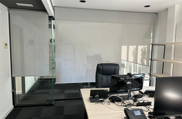 Instalación de cortinas enrollables con tejido técnico screen, referencia 380P abertura del 5% y color White/Pearl, en oficinas de Barcelona