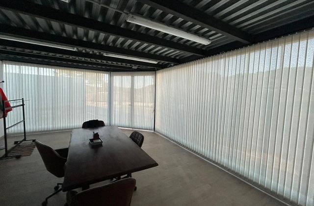 Instalación de cortinas verticales con tejido técnico screen y lamas de 89mm, referencia 380P abertura del 5% y color White, en oficinas de Dosrius (Barcelona)