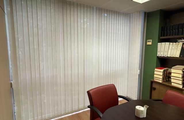 Instalación de cortinas verticales con tejido técnico screen y lamas de 89mm, referencia 390P abertura del 3% y color White/Linen, en oficinas de Barcelona