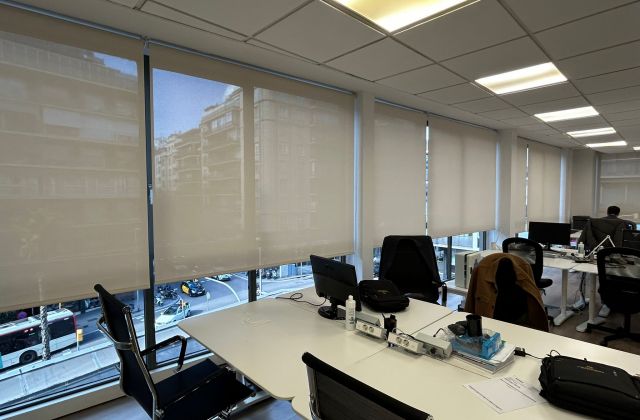 Instalación de estores enrollables con tejido técnico screen, referencia 380P abertura del 5% y color White/Linen, en oficina de Barcelona