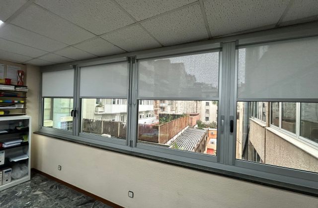 Cortinas sistema fit box con tejido tecnico screen de color gris instaladas en oficina en Barcelona