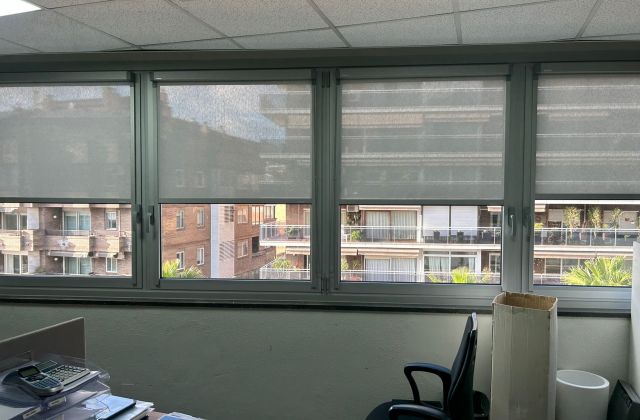 Instalación de cortinas enrollables sistema fitbox con componentes de color gris, instaladas en oficinas de l'Hospitalet del LLobregat