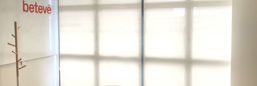 Estores enrollables blancos instalados en ventanal de sala de reuniones en una oficina de Barcelona