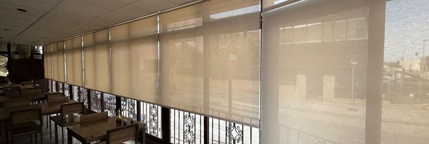 Cortinas enrollables con tejido técnico screen instaladas en sala de restaurante en Vilassar de Mar