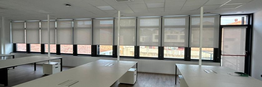 Cortinas enrollables con tejido técnico screen instaladas en las ventanas y ventanales de unas oficinas en Rubí