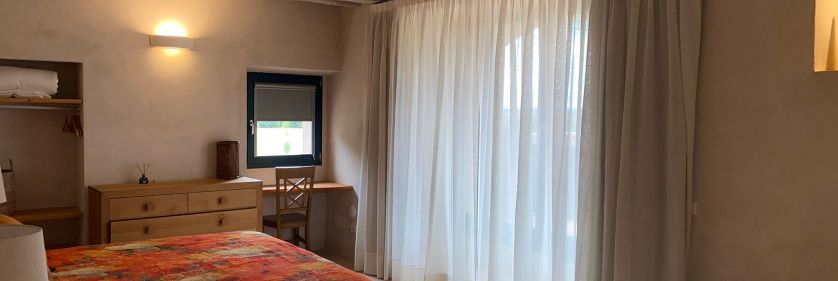 Cortinas tradicionales y cortina minifast instaladas en ventana de dormitorio en Besalú