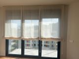 Instalación de cortinas plegables con tejido 100% poliéster, referencia SE12 y color Beige, en vivienda de Arenys de Mar