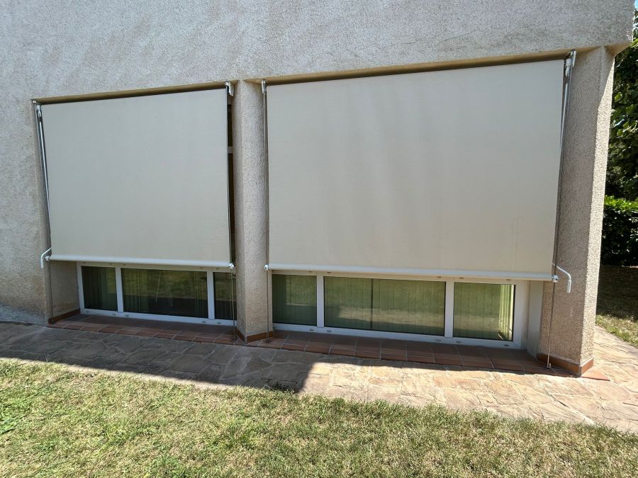 Cortina exterior con varilla y accionamiento a manivela instalada en ventanales de casa particular en Corbera del Llobregat