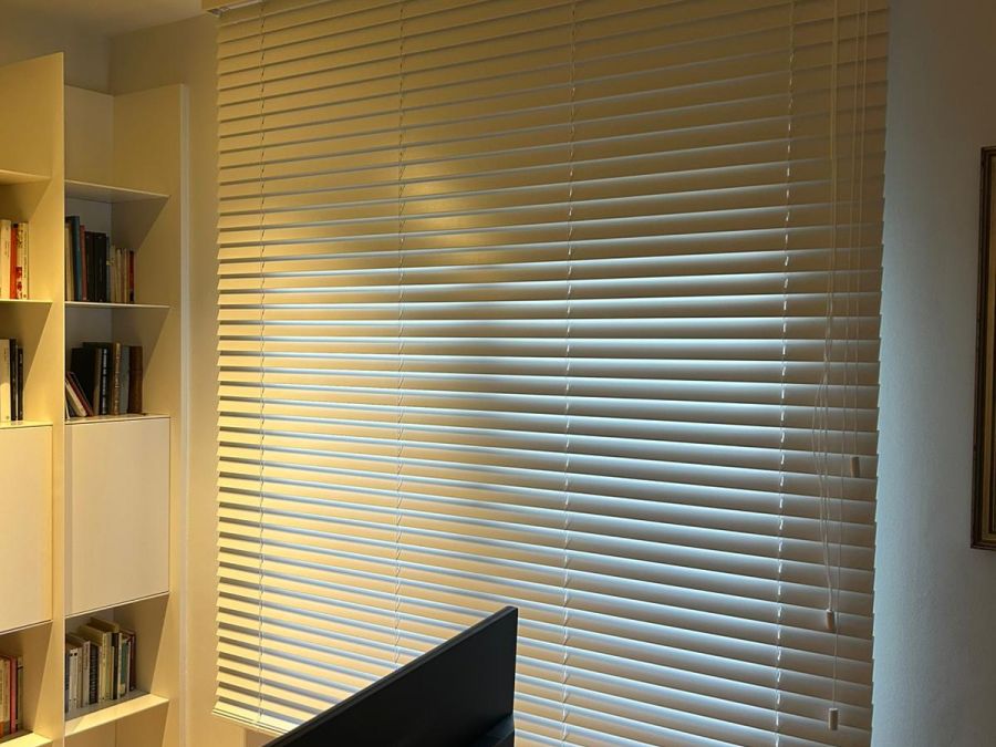 Cortina veneciana de aluminio de lamas de 50mm de color blanco con accionamiento a cordón, instalada en despacho en Barcelona