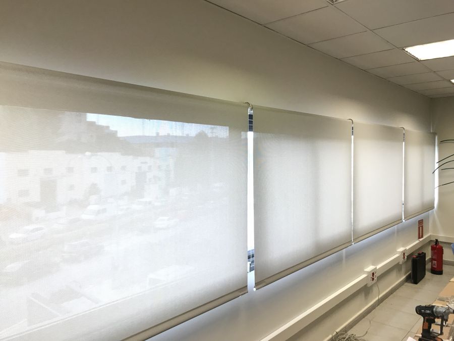Cortinas enrollables de color blanco, con tejido técnico screen instaladas en los ventanales de una oficina de Barcelona