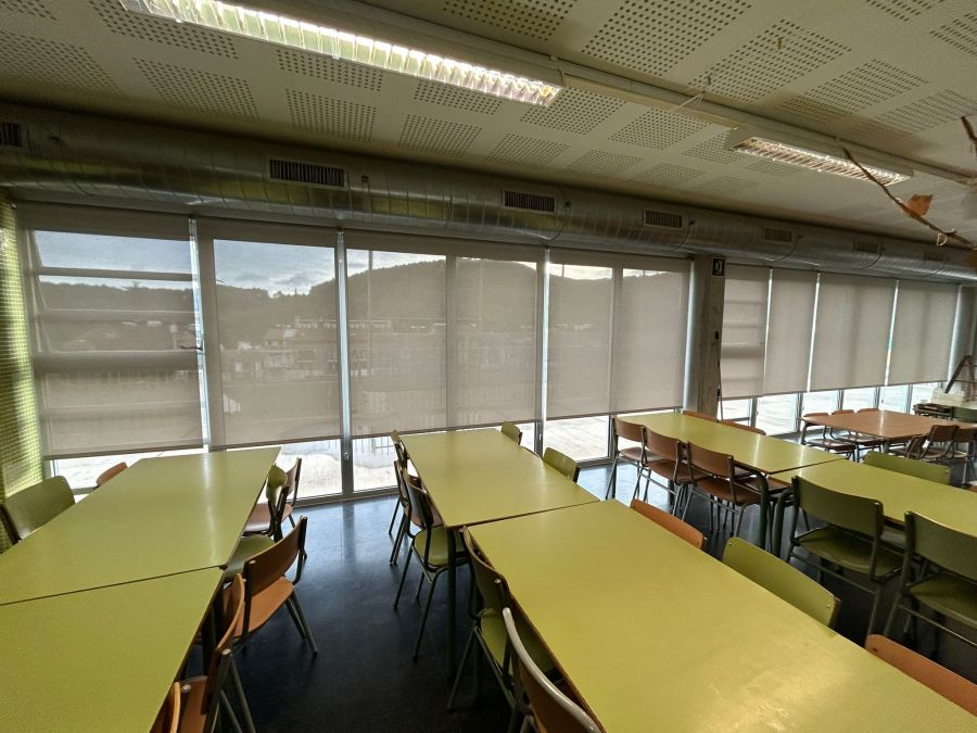 Cortinas enrollables con tejido técnico screen de color blanco perla instaladas en comedor de colegio en La Palma de Cervelló, Barcelona