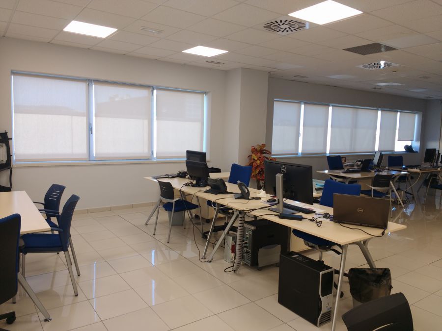 Cortinas enrollables con tejido técnico screen de color blanco instaladas en oficina en la Zona Franca en Barcelona