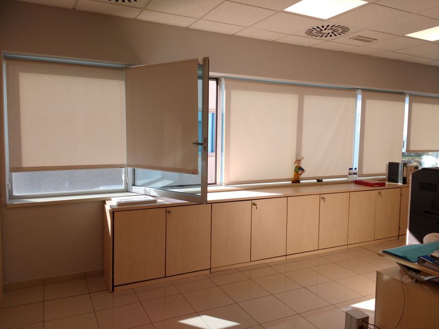 Cortinas enrollables con tejido técnico screen de color blanco instaladas en oficina en la Zona Franca en Barcelona