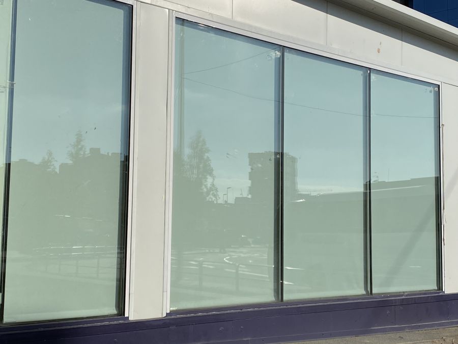 Cortinas enrollables opacas instaladas en escaparate de tienda, visto desde la calle