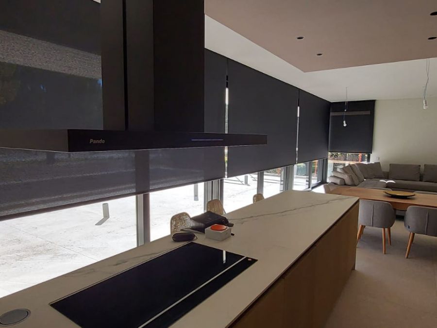 Cortinas enrollables negras instaladas en cocina comedor en vivienda en Begues
