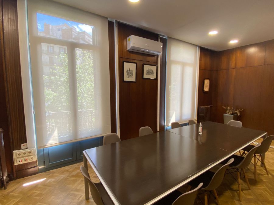 Cortinas enrollables de color blanco con tejido técnico screen, instaladas en sala de reuniones en oficina de Barcelona