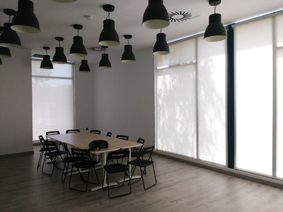 cortinas enrollables con tejido tecnico screen de color blanco instaladas en sala de dentro de salud mental en el barrio de Sant Andreu de Barcelona