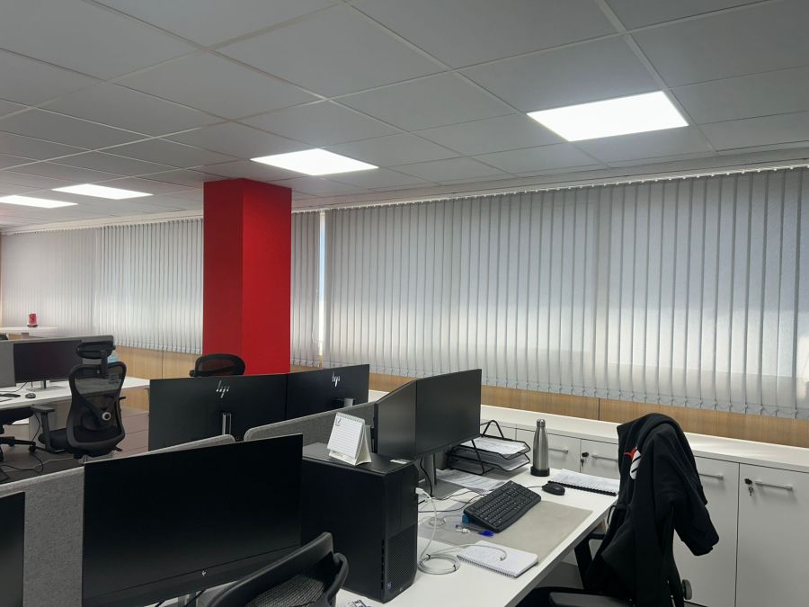 Cortinas verticales de lamas de 89mm y tejido técnico screen de color blanco, instaladas en oficina en Barberà del Vallès