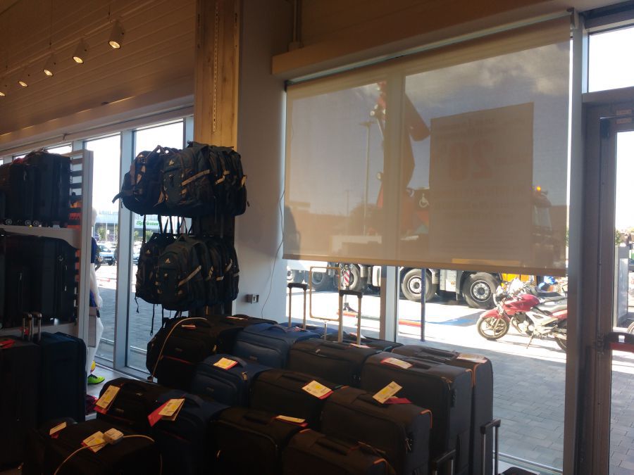 Cortinas enrollables motorizadas con tejido técnico screen instaladas en tienda de centro comercial en Terrassa