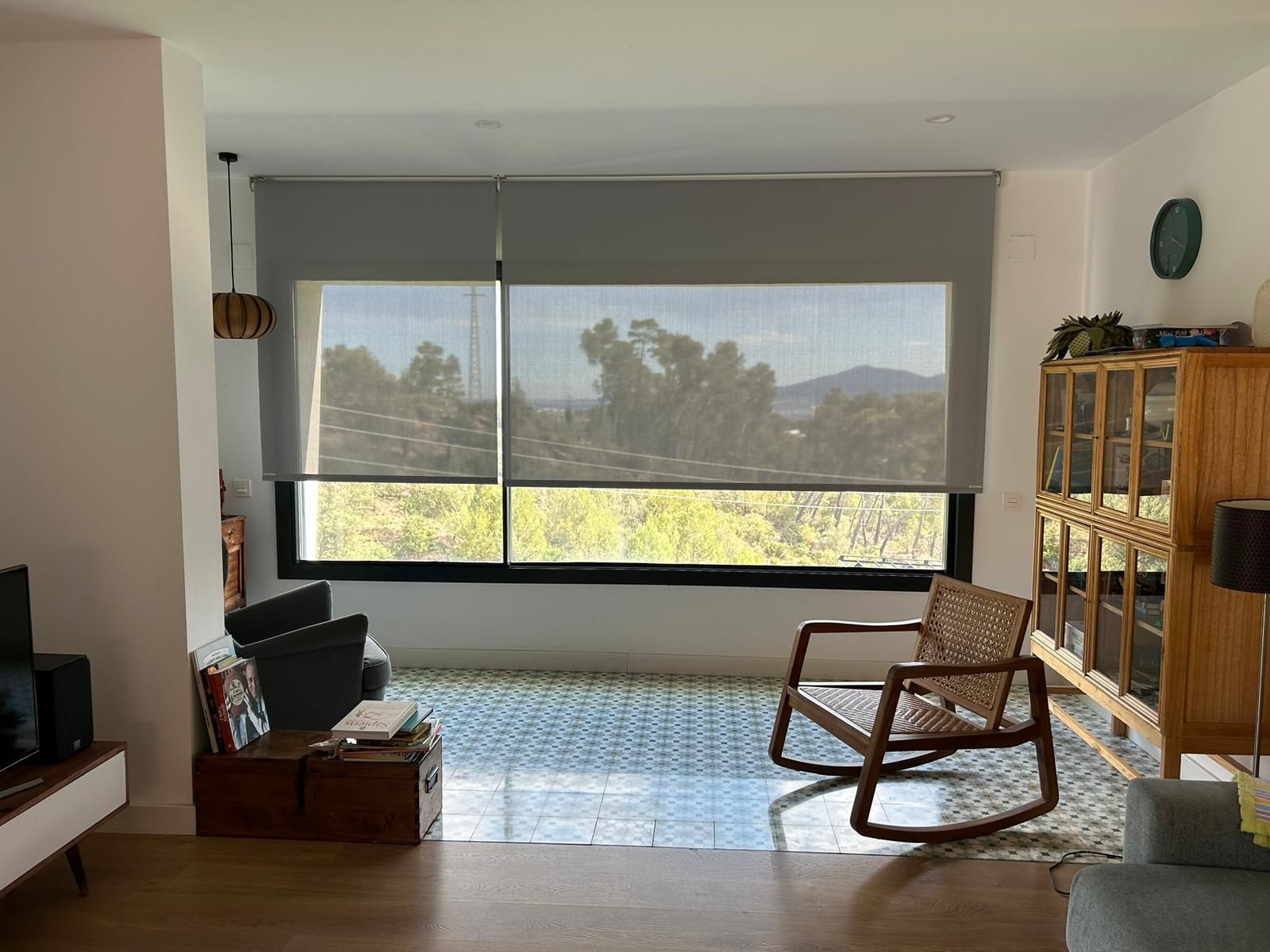 Cortina enrollable con tejido técnico screen, accionada a motor en ventanal del salón de una vivienda