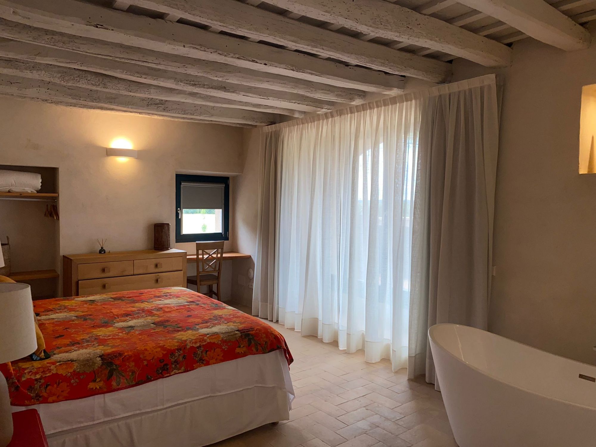 Cortinas tradicionales y cortina minifast instaladas en ventana de dormitorio en Besalú