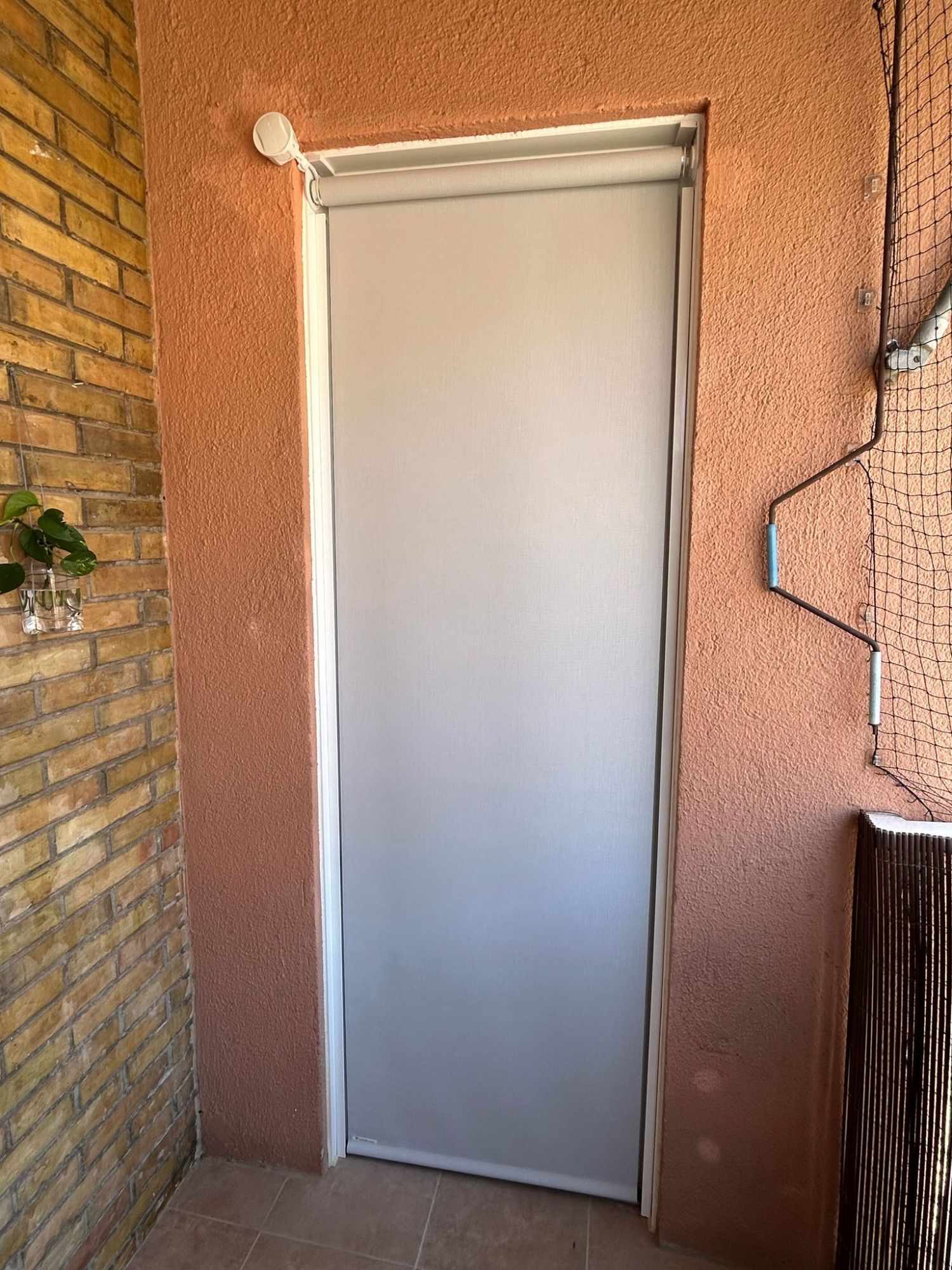 Instalación de cortina enrollable exterior motorizada y con tejido opaco, referencia Opac400 y color 007007, en vivienda de Barcelona