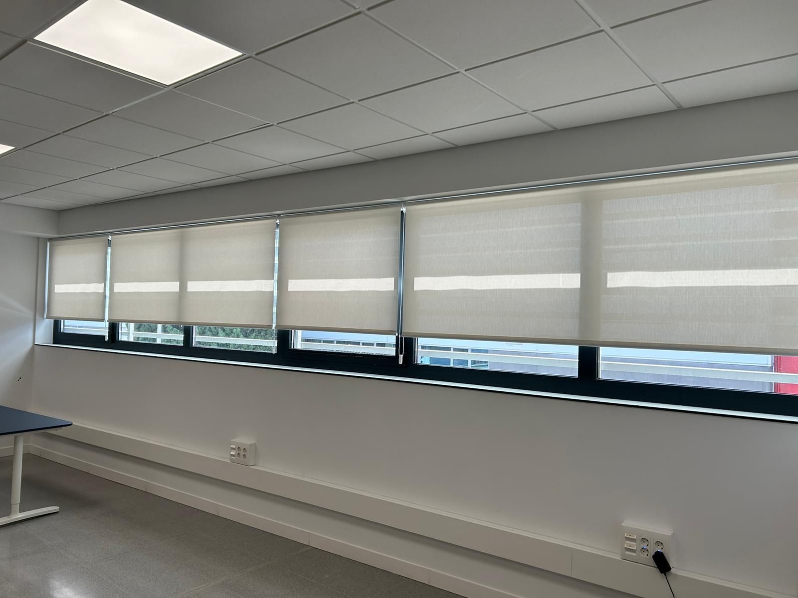 Instalación de cortinas con tejido técnico screen, abertura del 1% Referencia 420P y color White, en oficinas de Sant Feliu de Llobregat