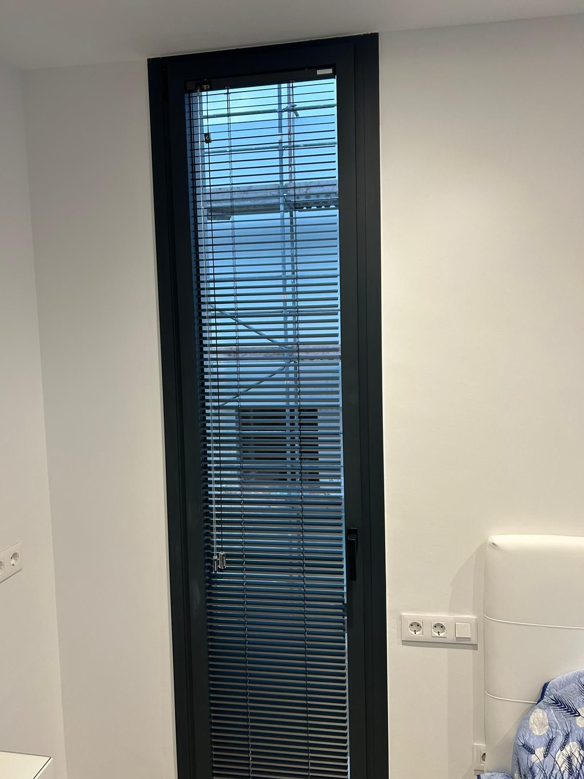 Instalación de cortina veneciana de aluminio de 25mm con escalerilla, modelo Signum y color negro, en vivienda de Montgat