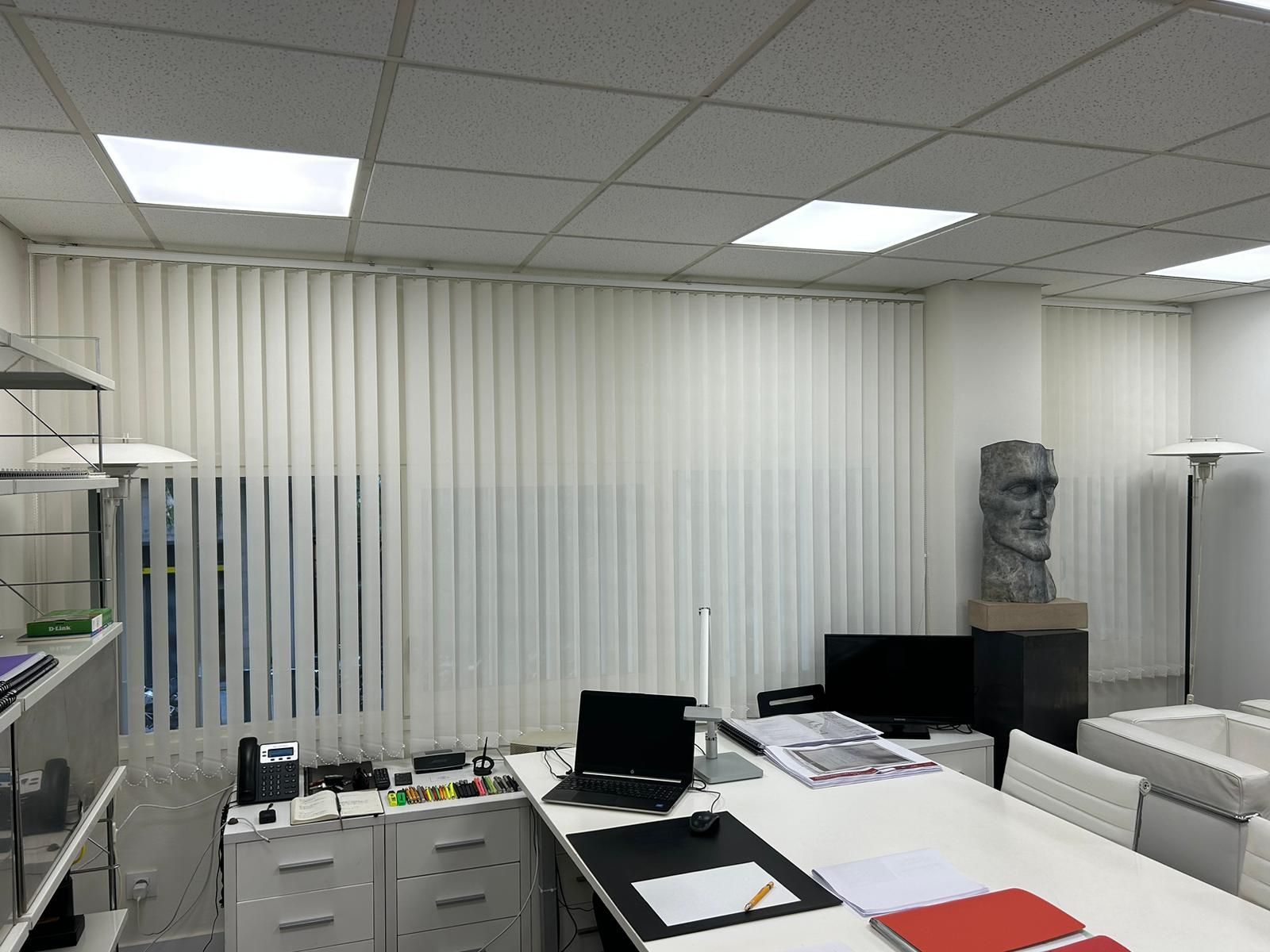 Instalación de cortinas verticales con tejido técnico screen y lamas de 89mm, referencia WOW White y abertura del 10%, en oficinas de Barcelona