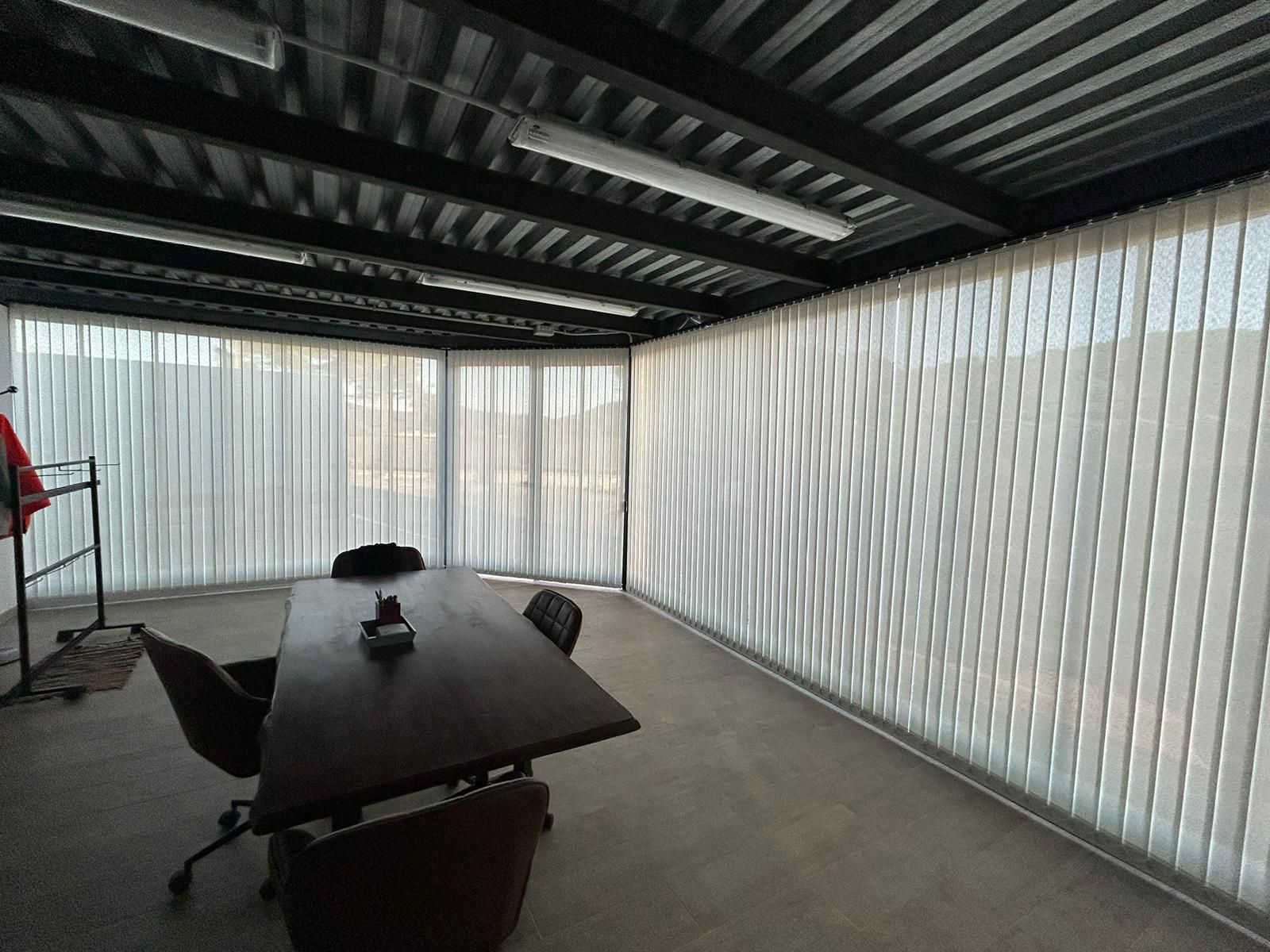 Instalación de cortinas verticales con tejido técnico screen y lamas de 89mm, referencia 380P abertura del 5% y color White, en oficinas de Dosrius (Barcelona)
