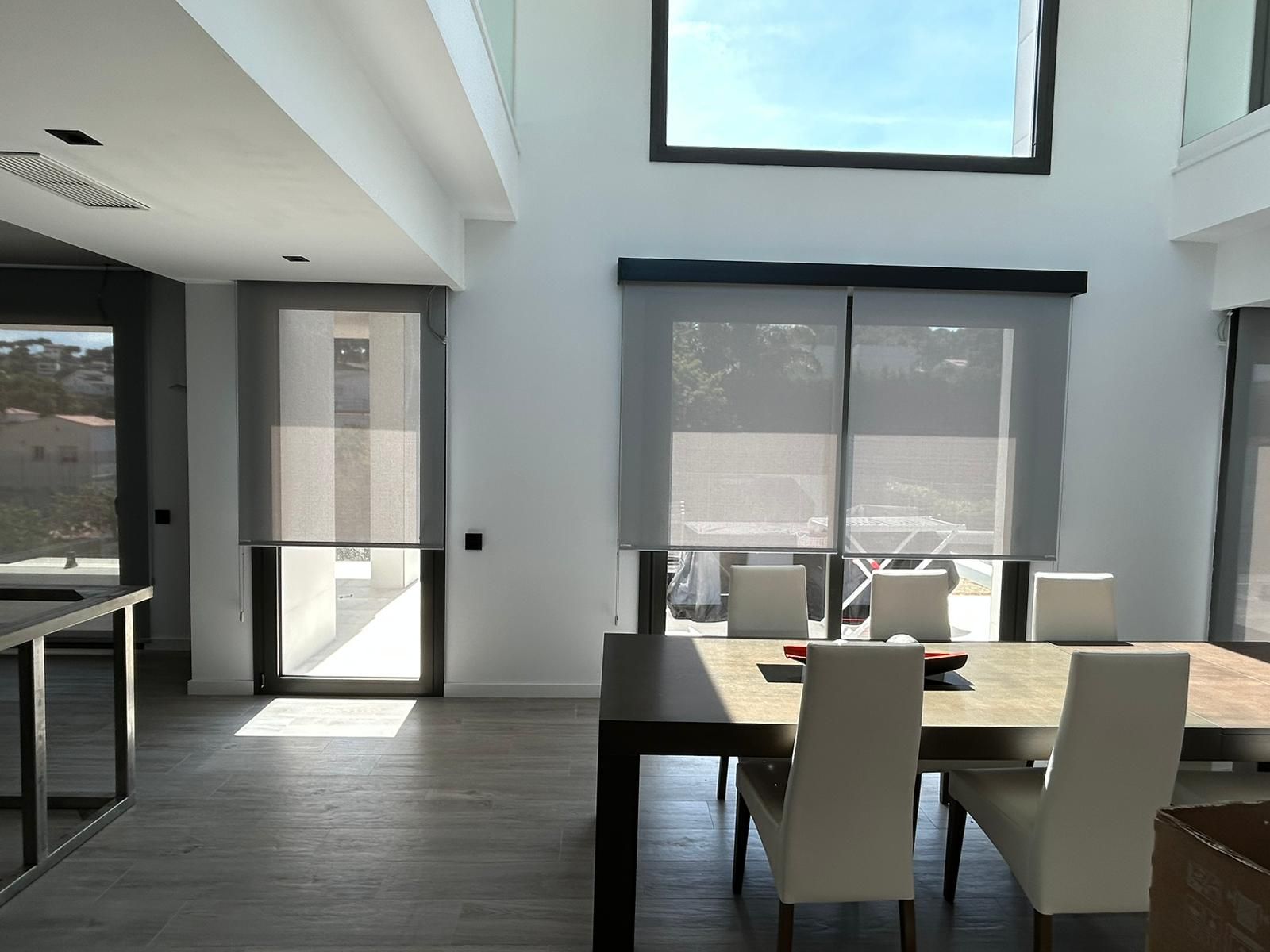 Instalación de cortinas enrollables con tejido técnico screen, referencia Natté 380P abertura del 5% color Pearl/Grey, instaladas en vivienda de Castelldefels
