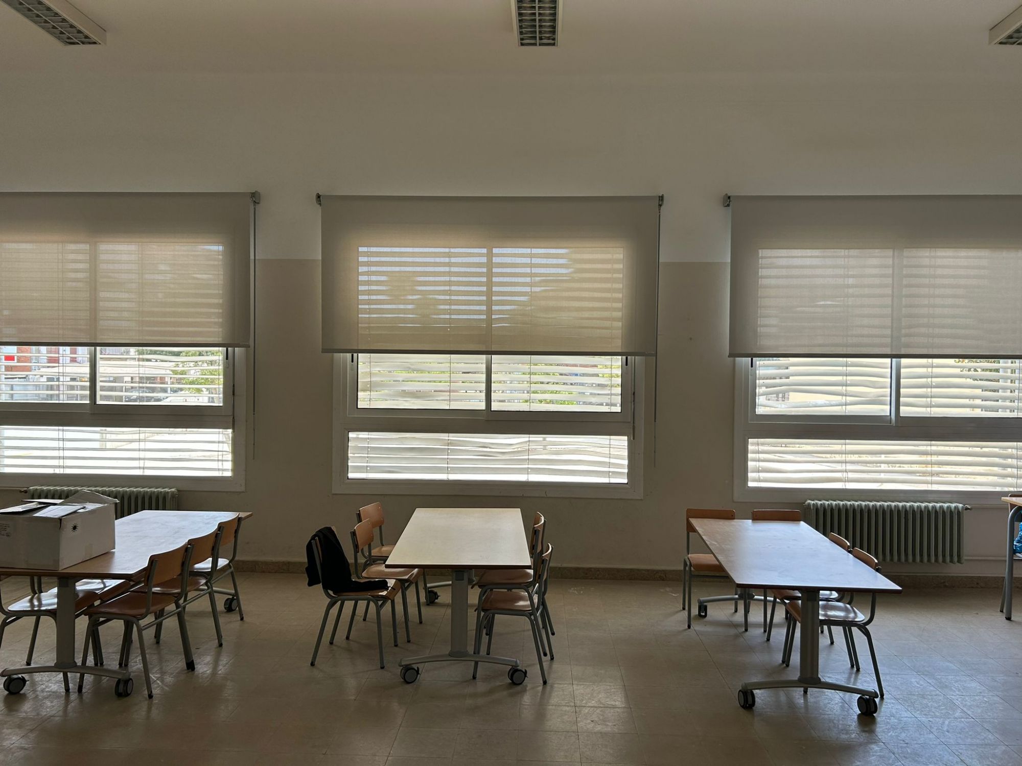 Instalación de cortinas enrollables con tejido técnico screen, referencia 420P abertura del 1% y color White/Pearl, en escuela de Viladecans