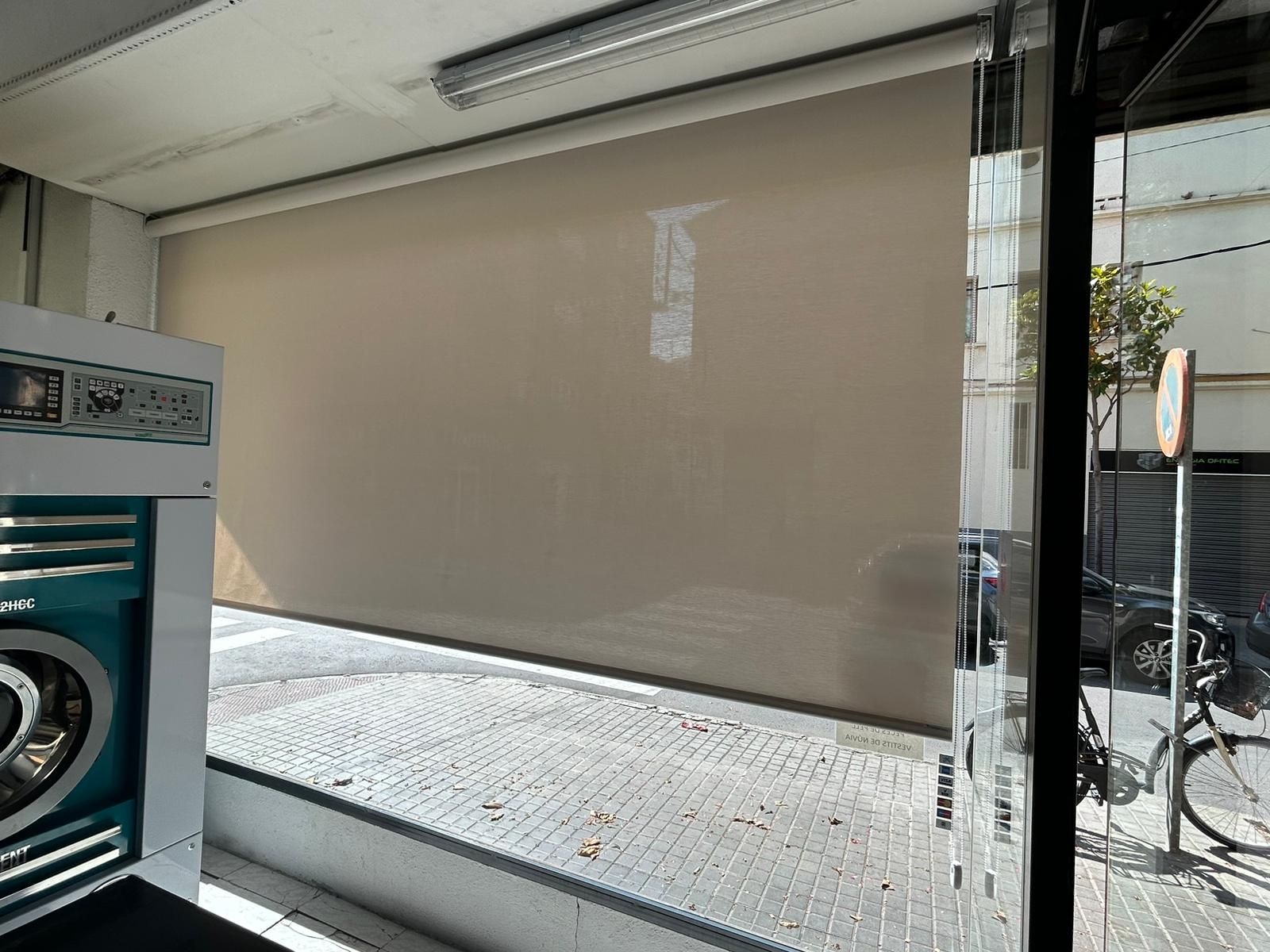 Instalación de estore enrollable con tejido técnico screen, referencia 420P abertura del 1% y color White/Linen, en tintorería de Badalona