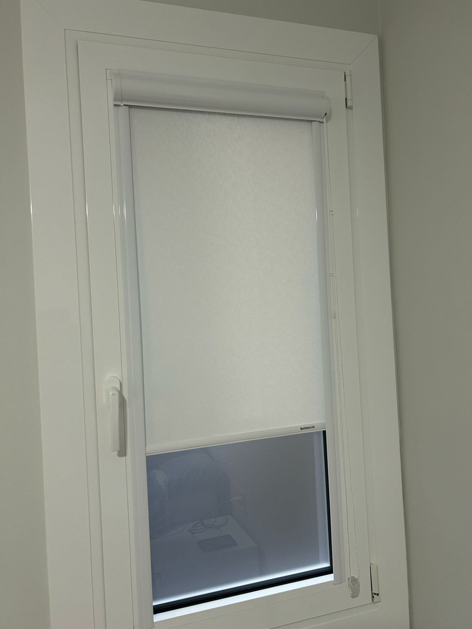 Instalación de cortina enrollable en sistema FIT guía plana, referencia PS403 abertura del 3% y color white linen, en vivienda de Barcelona