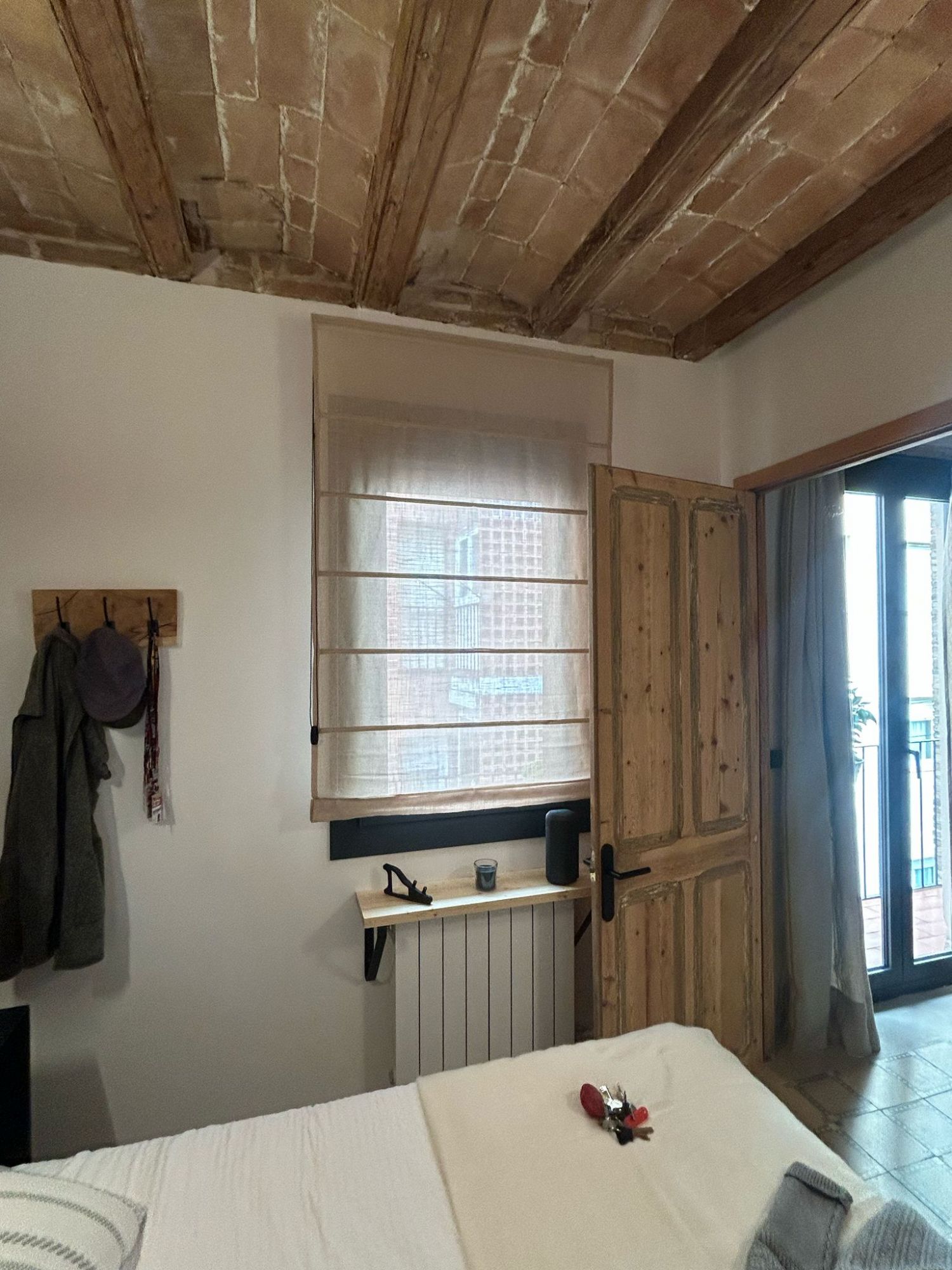 Instalación de cortina plegable con tejido Yutes, referencia Neutra 50% poliéster 50% lino  y color 14 Arena, en vivienda de Barcelona