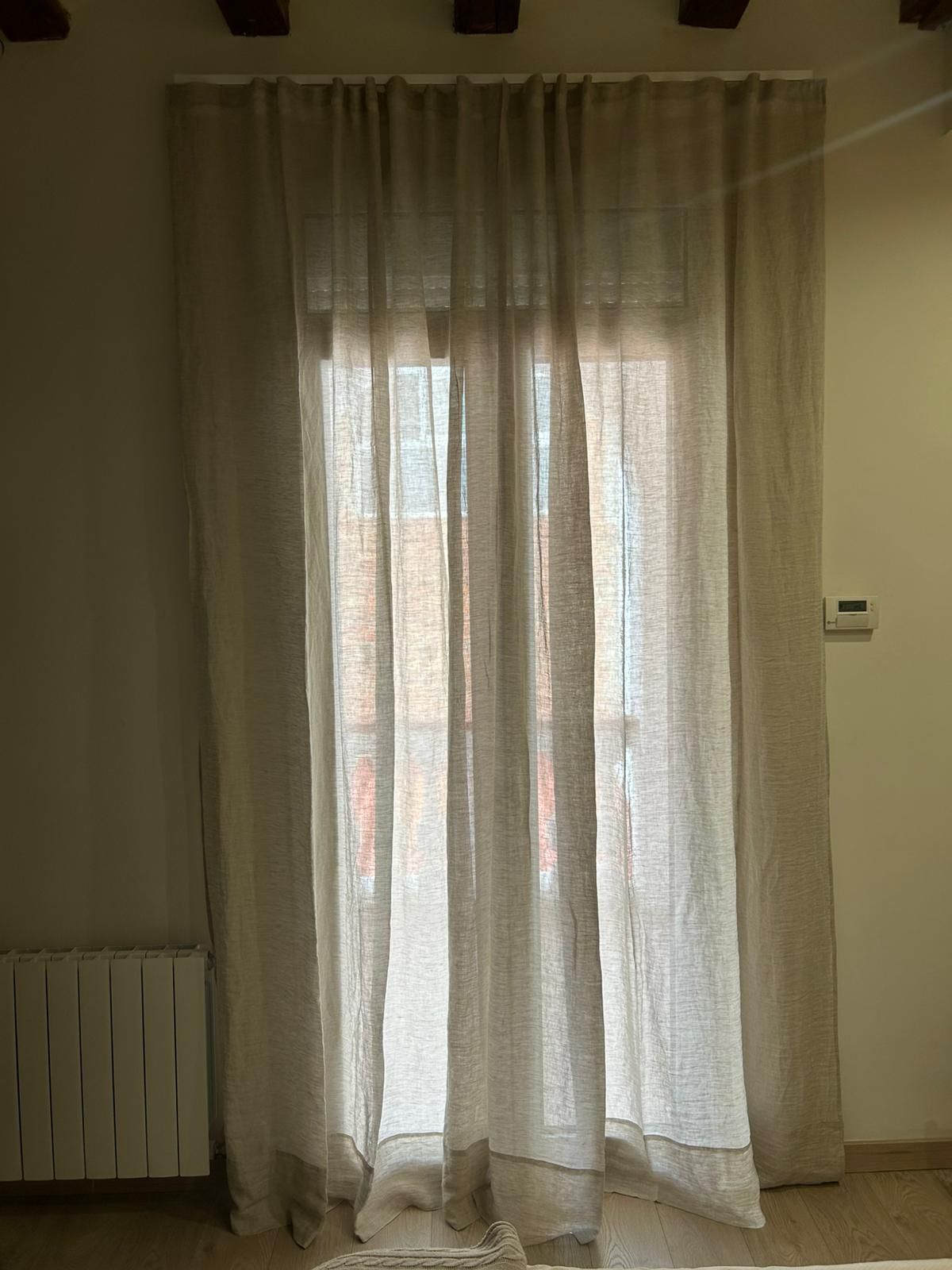 Instalación de cortina tradicional con tejido 100% lino, confección plana doble tela color 95 y partida, en vivienda de Barcelona