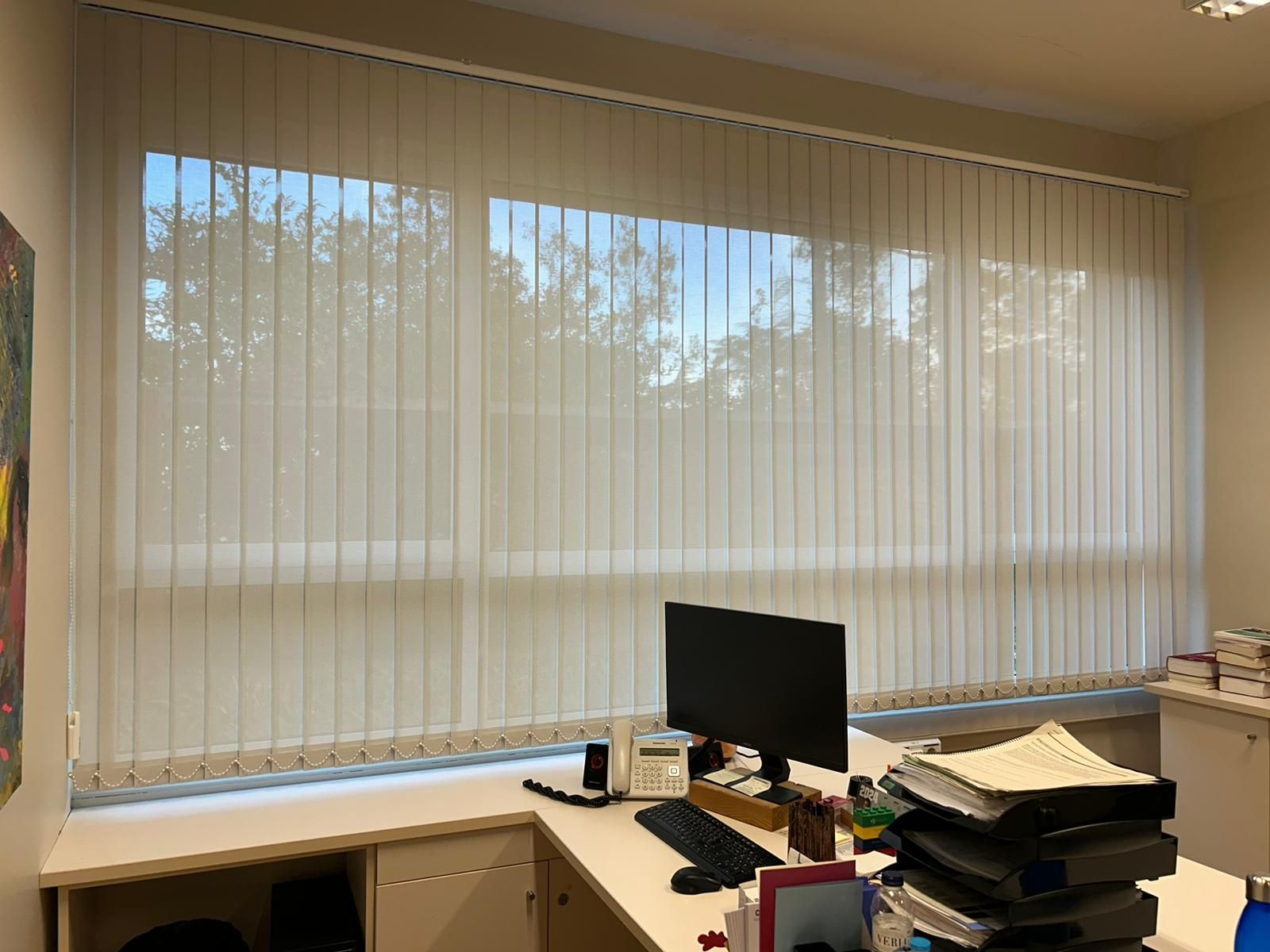 Instalación de cortina vertical con tejido técnico screen y lamas de 89mm, referencia PS351 abertura del 1% y color White/Pearl, en oficinas de Barcelona