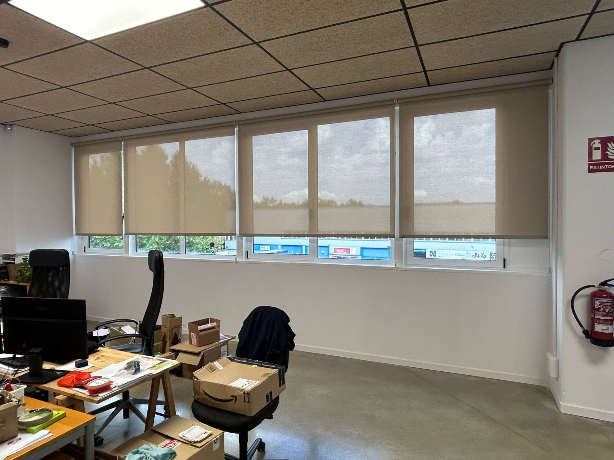 Instalación de cortinas enrollables con tejido técnico screen Bandalux, referencia 403/28958 abertura del 3% y color Cinder, en oficinas de Badalona 