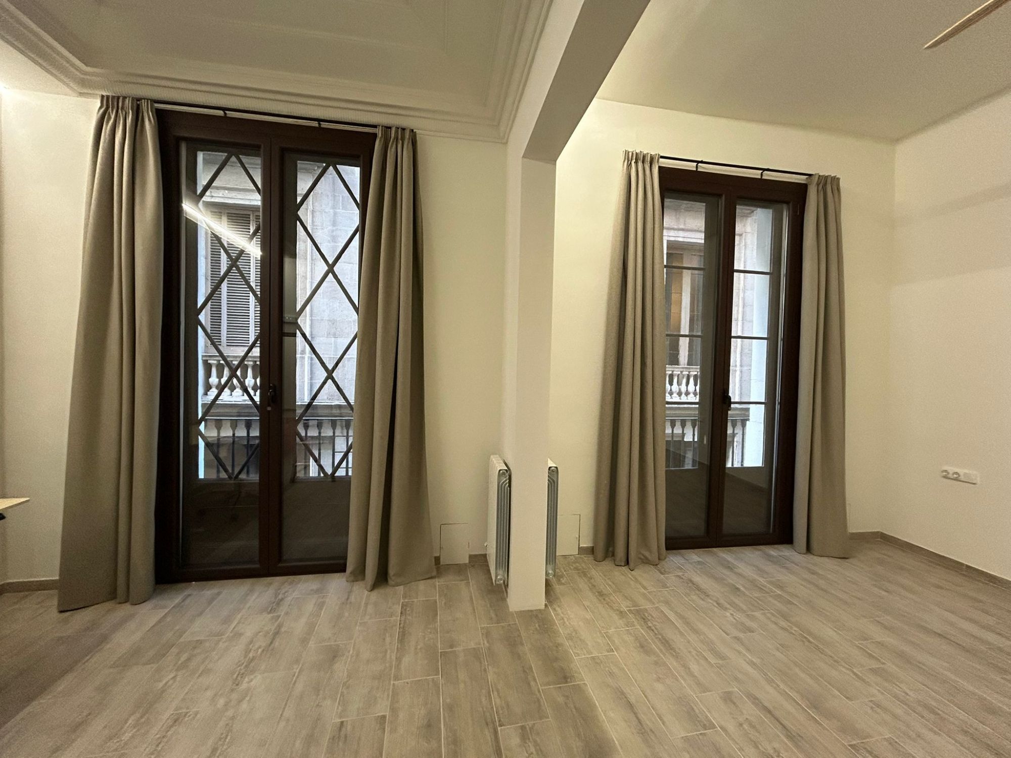 Instalación de cortinas tradicionales con tejido opaco, color TAP DC 5004, en vivienda de Barcelona